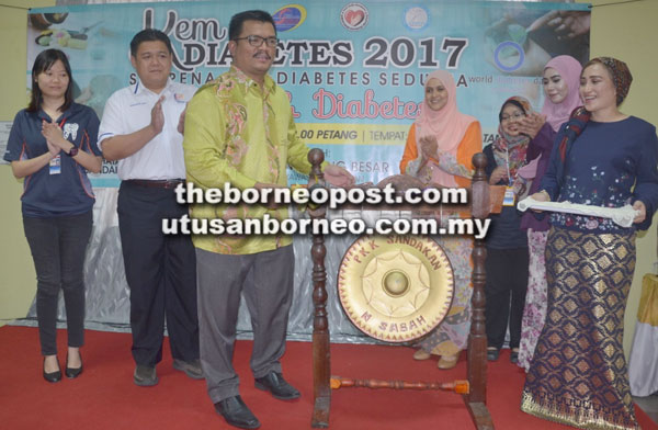  Dr Joiari (tiga kiri) memalu gong sebagai simbolik perasmian Kem Diabetes 2017 di Klinik Kesihatan Sandakan.