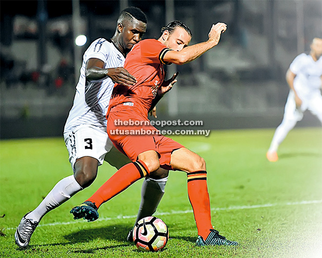  Pemain import Sarawak, Mateo Roskam diasak oleh pemain Import TTeam, Abdoulaye Youssouf Maiga pada saingan Liga Super di Stadium Negeri Kuching malam kelmarin. Gambar sisipan Pengiran Bala. — Gambar Bernama