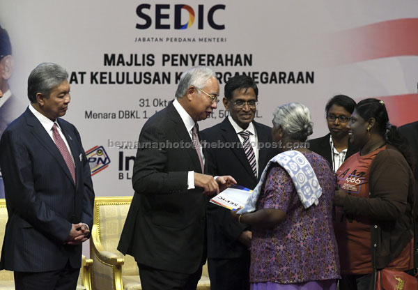  Najib (dua kiri) menyerahkan Surat Kelulusan Kewarganegaraan kepada salah seorang daripada 30 masyarakat India yang memohon di Wisma Dewan Bandaraya Kuala Lumpur semalam. — Gambar Bernama