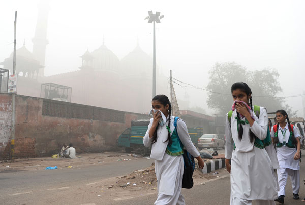  Para pelajar berjalan kaki ke sekolah dalam asbut tebal di New Delhi, semalam. — Gambar AFP