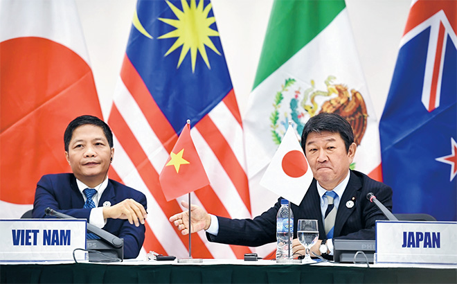  Motegi berjabat tangan dengan Menteri Dagangan Vietnam Tran Tuan Anh (kiri) semasa sidang akhbar mengenai TPP pada sampingan sidang kemuncak APEC di Danang, semalam. — Gambar AFP