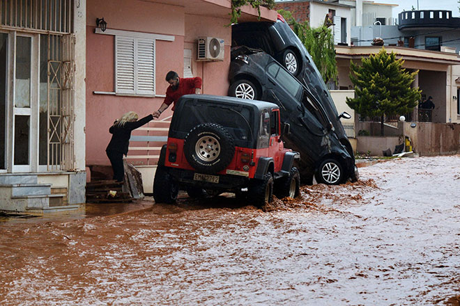  Seorang lelaki membantu memindahkan seorang wanita dari banjir di Mandra di barat Athens, kelmarin. — Gambar AFP