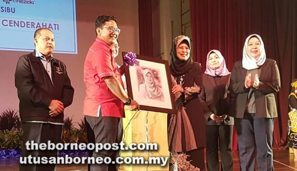  Razin (dua kiri) menyampaikan cenderamata kepada Fatimah selepas menyempurnakan Program Digital Kenyalang Edisi Sibu semalam.