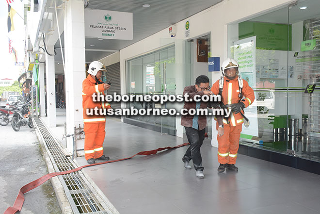  Anggota bomba membawa keluar seorang kakitangan Tabung Haji Limbang.