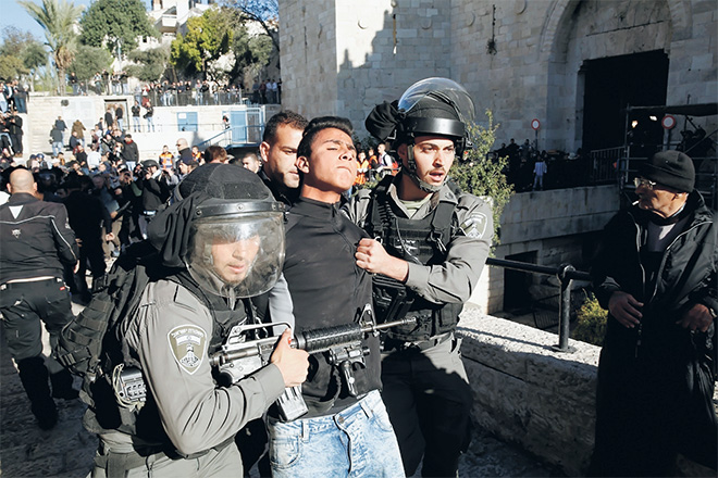  Anggota polis sempadan rejim Israel menahan seorang pemuda Palestin yang merusuh di Pintu Damsyik selepas solat Jumaat di Kota Lama Baitulmaqdis, kelmarin. — Gambar Reuters