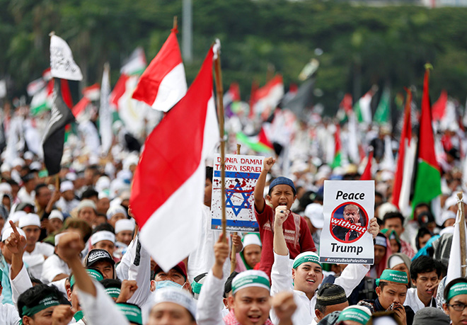  Penunjuk perasaan membawa sepanduk mengecam Trump dan rejim Israel semasa menyertai demonstrasi di Tugu Negara Monas di Jakarta, semalam. — Gambar Reuters