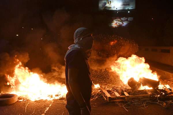  Penyokong Nasralla membakar tayar ketika protes di Tegucigalpa kelmarin. — Gambar AFP