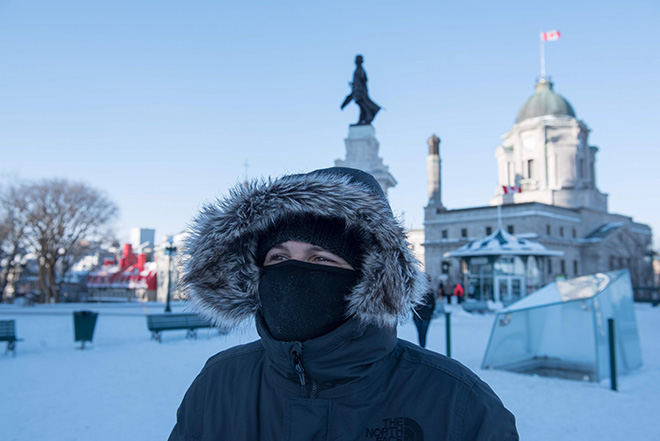  Penduduk memakai penutup hidung dan mulut ketika keluar dari rumah pada hari yang dingin luar biasa di Quebec City, Kanada kelmarin. — Gambar AFP