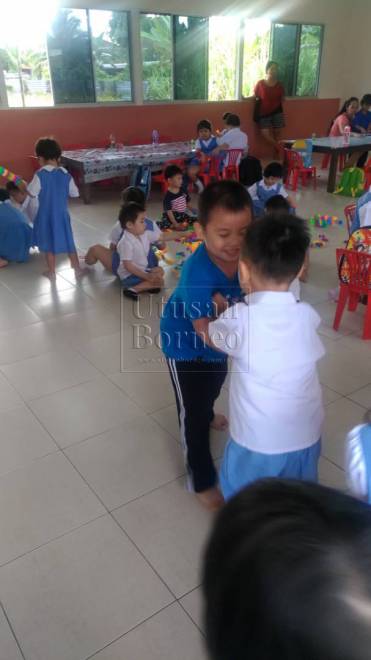 Dua orang kanak-kanak lelaki pra sekolah sedang bermain ala berlawan di Tadika Methodist, Siburan.