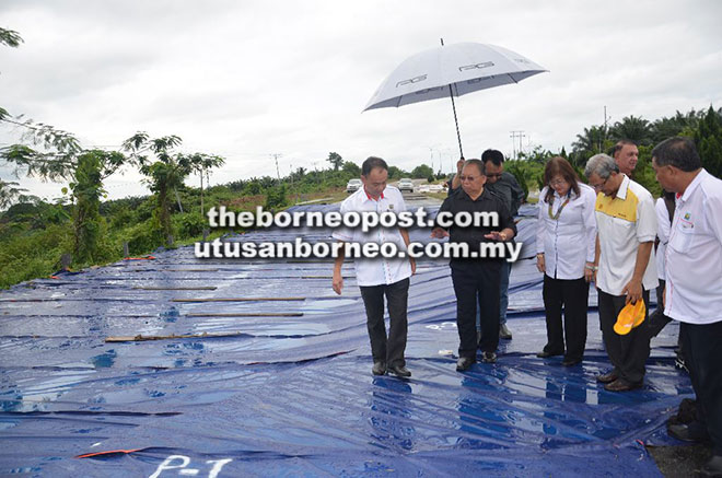  Pairin menyatakan sesuatu kepada para pemimpin yang turut menyertai rombongan kerjanya mengenai situasi jalan raya yang mendap di KM251.6 Jalan Sandakan-Tawau.