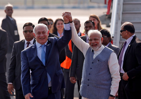  Netanyahu (kiri) dan Modi mengangkat tangan selepas perdana menteri Israel itu tiba di lapangan terbang New Delhi, India, kelmarin. — Gambar Reuters