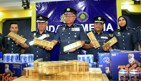  Zulkifli (tengah) menunjukkan rokok yang dirampas ketika mengadakan sidang media mengenai kes tangkapan dan rampasan minuman keras dan rokok di Kota Kinabalu, semalam. — Gambar Bernama