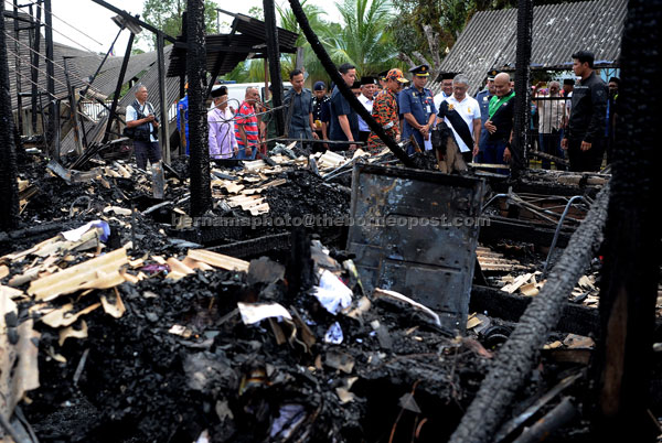  Tengku Abdullah (empat kanan) semalam melawat beberapa rumah yang musnah dalam kebakaran petang kelmarin                 di Kampung Sungai Isap di Kuantan. — Gambar Bernama