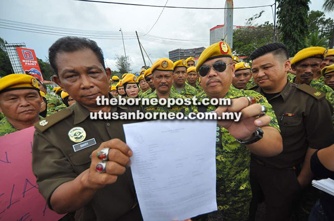  Bakry (dua kiri) dan Jafrin menunjukkan laporan polis yang dibuat di IPD Kota Kinabalu pada Rabu.