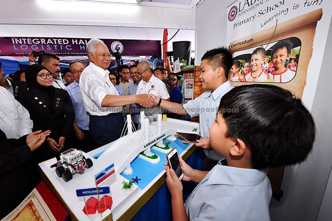  Najib melihat replika Jambatan Labuan magnetik yang direka oleh pelajar Sekolah Antarabangasa Labuan pada Pelancaran Labuan Development Blueprint 2030 di Dataran Labuan semalam. — Gambar Bernama