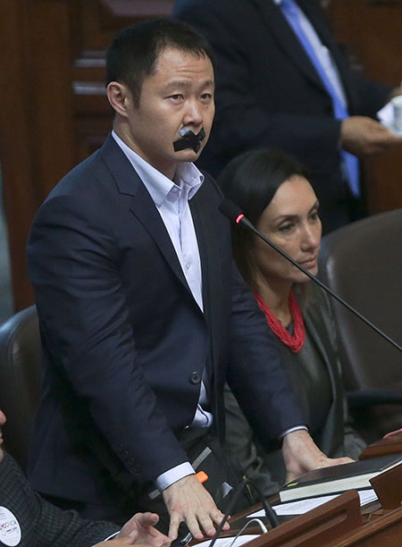  Kenji Fujimori berdiri dengan pita menutupi mulutnya  ketika membantah keputusan oleh partinya sendiri semasa              persidangan di Lima kelmarin. — Gambar AFP