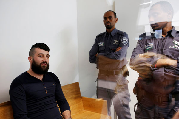  Harouf duduk di mahkamah  Tel Aviv kelmarin sambil diawasi dua pengawal penjara Israel selepas dia mengaku bersalah atas tuduhan membunuh Halimi. — Gambar Reuters