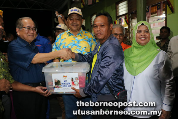  Shahidan menyaksikan pengagihan kit bantuan kepada mangsa yang disampaikan Uggah. Turut kelihatan Rubiah.