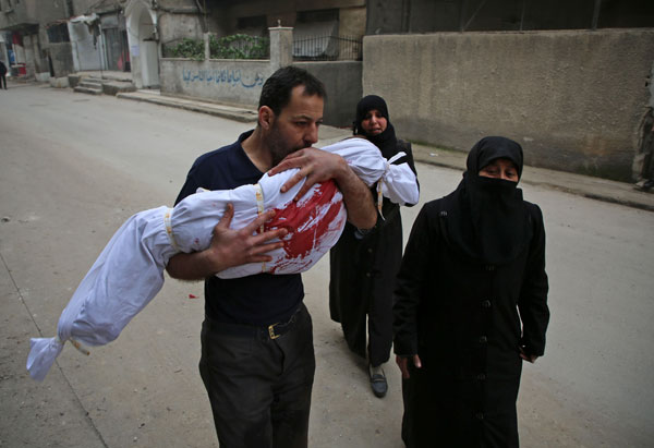  Seorang lelaki mencium jenazah anak perempuannya, yang terbunuh dalam serangan udara, sebelum pengebumiannya di Zamalka, dekat ibu negara Damsyik, Syria kelmarin. — Gambar AFP