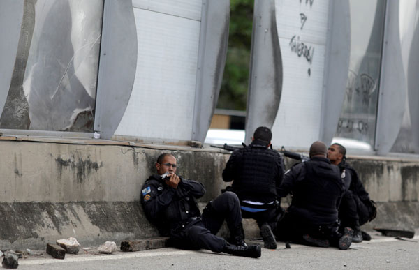  Anggota polis bersiap sedia di tembok lebuh raya semasa operasi menentang pengedar dadah berhampiran kawasan sesak Mare di Rio de Janeiro, Brazil kelmarin. — Gambar Reuters
