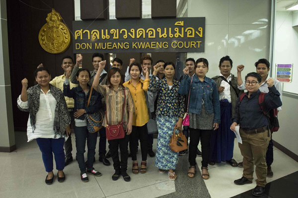  Pekerja pendatang dari Myanmar menunjukkan isyarat ingkar di hadapan media sebelum memasuki Mahkamah Majistret Don Muang di Bangkok semalam untuk berdepan tuduhan memfitnah ladang ayam Thammakaset kerana mendakwa berlaku penderaan buruh. — Gambar AFP