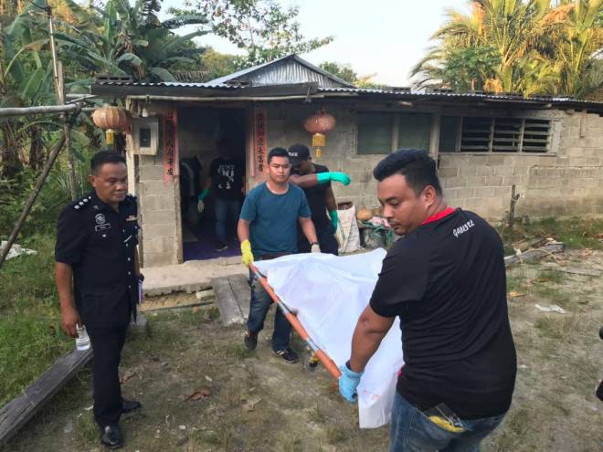 Polis mengusung mayat keluar dari rumah.