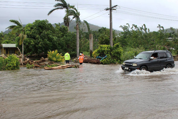  Gambar serahan Palang Merah Samoa semalam menunjukkan sebuah kereta meredah jalan yang ditenggelami air ketika para pekerja bantuan memeriksa sebuah rumah di kawasan Apia. — Gambar AFP