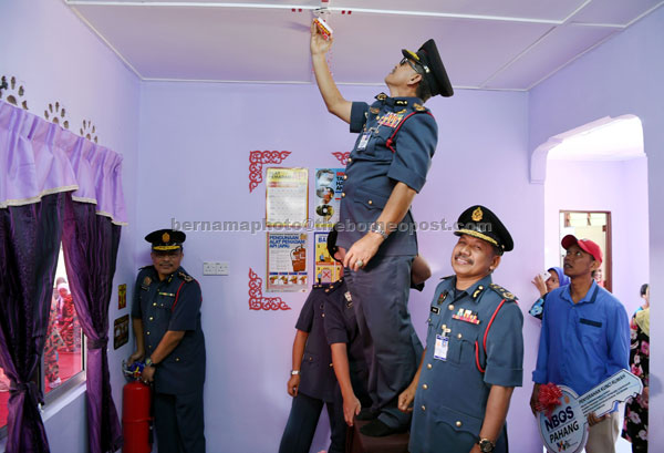  Mohd Sharkar (kiri) memasang alat pemadam kebakaran sementara Wan Mohd (tiga, kanan) memasang alat pengesan kebakaran di dalam rumah Abdul Rahim Seman, 40, (kanan) pada majlis penyerahan Kunci Rumah Program Strategi Lautan Biru Kebangsaan ke-7 (NBOS7) Kementerian Kesejahteraan Bandar, Perumahan dan Kerajaan Tempatan di Kampung Teris, Lanchang, semalam. — Gambar Bernama