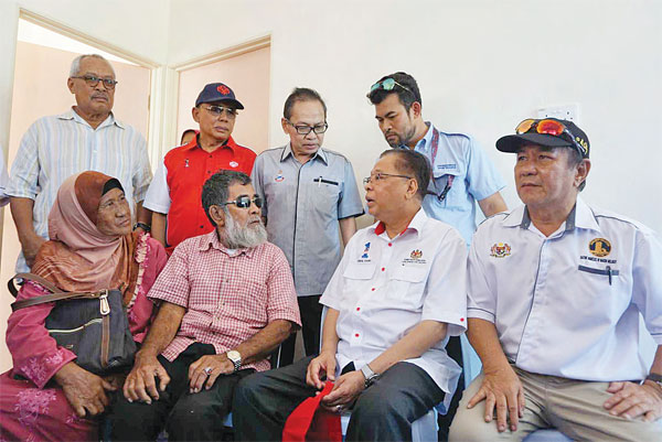 ISMAIL (depan dua kanan) berbual mesra dengan penerima bantuan PPRT Harsat Sait (depan dua kiri).