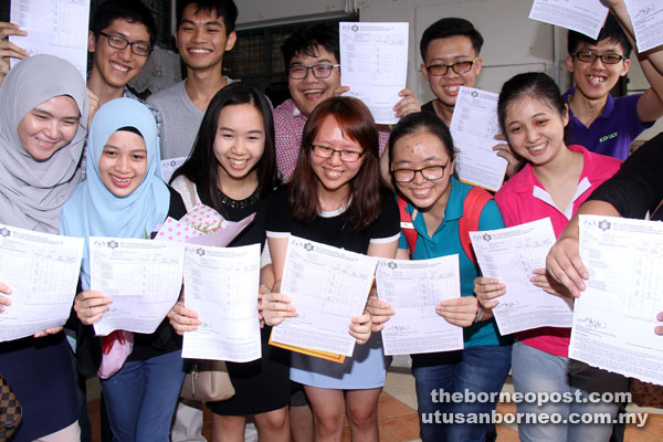 Foto fail menunjukkan lulusan STPM dari SMK St Thoma di Kuching yang mencapai keputusan cemerlang menunjukkan sijil masing-masing pada tahun lepas. 