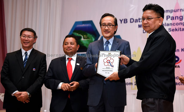  Masidi menyampaikan sijil, plak penghargaan dan plak ‘Malaysia Tourism Quality Assurance (MyTQA)’ kepada Pengarah Urusan Tabin Wildlife Sabah Lawrence Chin (kanan) pada sesi penerangan kepada penggiat industri pelancongan Sabah semalam. — Gambar Bernama 