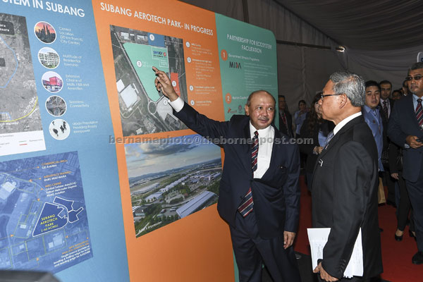  Mustapa (kanan) mendengar penerangan daripada pengerusi Malaysia Airports Tan Sri Syed Anwar Jamalullail semasa majlis pecah tanah Pusat Senior Aerospace  di Subang semalam. — Gambar Bernama