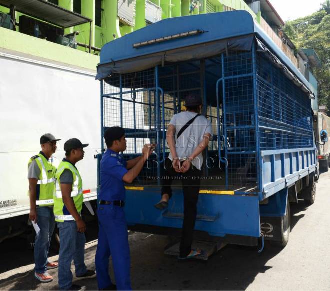 Salah seorang individu yang ditahan dibawa menaiki lori DBKK sebelum dihantar ke mahkamah.