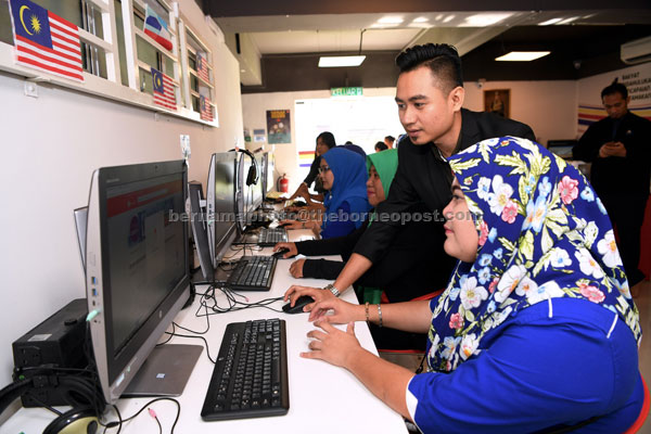  Nasrah (dua kanan) membantu usahawan dalam talian menggunakan kemudahan internet yang disediakan di PI1M PPR Taman Murni semalam. — Gambar Bernama 