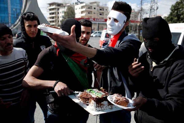 Penunjuk perasaan Palestin menyambut hari jadi rakan seperjuangan semasa berehat seketika daripada berdemonstrasi mengecam rejim Israel di Ramallah, Tebing Barat pada Jumaat lalu. — Gambar AFP
