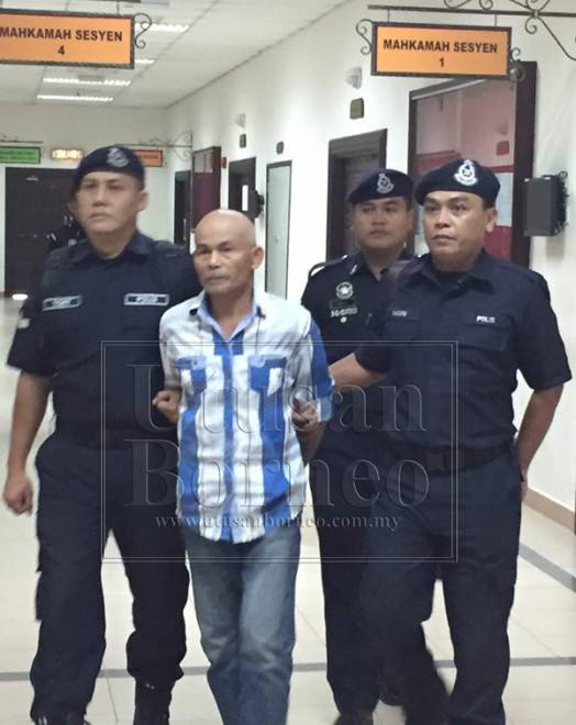 Motis diiringi polis ketika proses pendakwaan di Mahkamah Kuching.