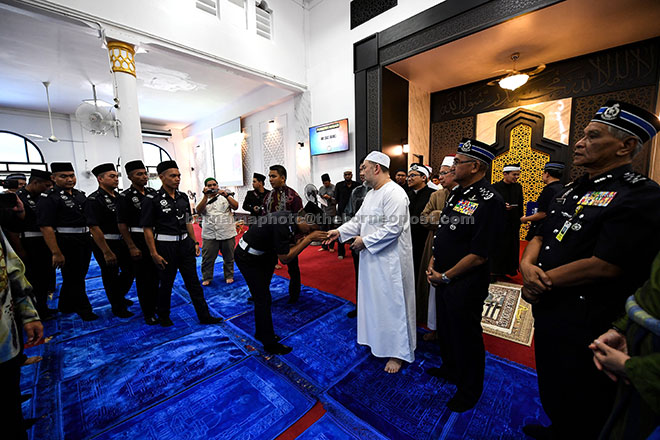  Sultan Muhammad V (tiga kanan) bersalam dengan sebahagian daripada anggota polis selepas selesai menunaikan solat Jumaat di Masjid Salehen, di Pulapol dekat Kuala Lumpur, semalam, sempena sambutan Peringatan Hari Polis yang ke-211 pada Ahad ini. — Gambar Bernama