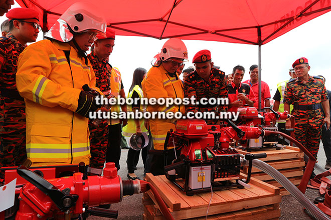  Uggah benung nguji ngidupka injin ‘portable fire pump’,  sama enggau iya nguji (kiba) Dr Sim.