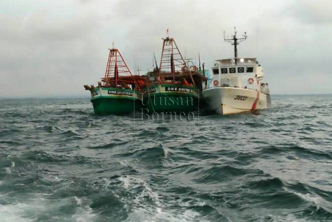 Kapal nelayan Vietnam yang ditahan bersama krunya diiring oleh kapal APMM (kanan) ke Pelabuhan Bintulu untuk siasatan lanjut.