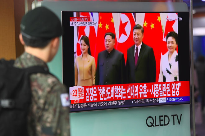  Seorang askar Korea Selatan menonton berita televisyen mengenai lawatan sulit oleh pemimpin Korea Utara ke China, di stesen kereta api di Seoul semalam. — Gambar AFP 