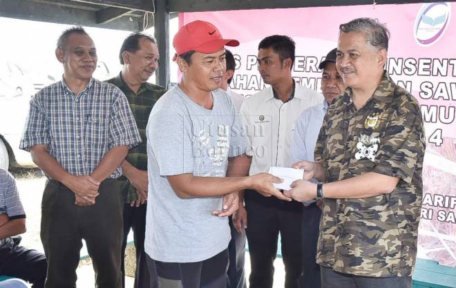 Arifin menyampaikan bantuan pembajakan kepada salah seorang pesawah sempena majlis itu.