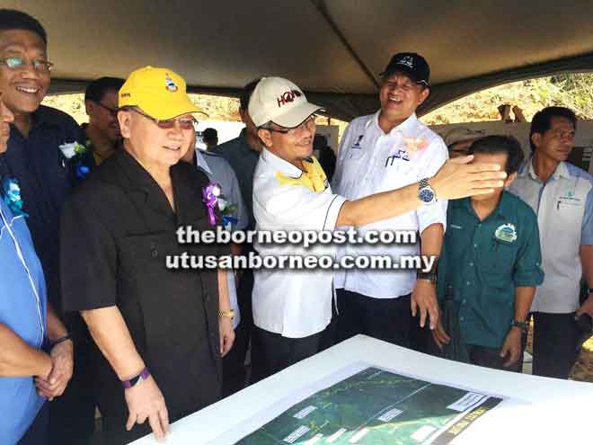  Amrullah (tiga kiri) memberi taklimat kepada Pairin (dua kiri) mengenai projek jalan sambil diperhatikan oleh dan Joniston (empat kiri).