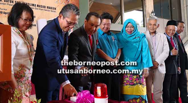  Dr Christina (kiri) menyaksikan Rosmadi (dua kiri) menyempurnakan gimik perasmian Pameran Aset Perubatan Klasik Borneo Utara di Kompleks Muzium Sabah.