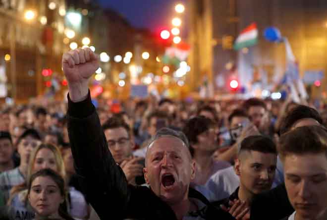  Seorang penunjuk perasaan melaungkan slogan anti-Orban ketika menyertai demonstrasi di Budapest, kelmarin. — Gambar Reuters