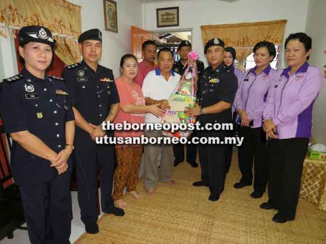  Merbin menyampaikan sumbangan kepada Simon sambil disaksikan yang lain semasa program Jejak Kasih IPD Padawan.