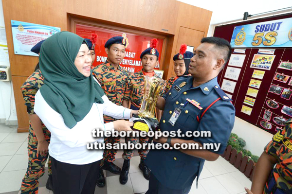 IBNU dan Rokiah meneliti piala yang dimenangi pasukan Sabah.