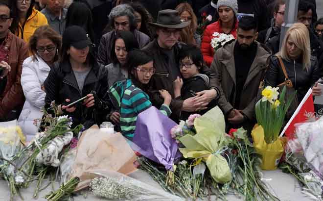  Orang yang berkabung menghadiri upacara khas untuk memberi penghormatan kepada mangsa sehari selepas seorang lelaki memandu van merempuh pejalan kaki di atas kaki lima yang sesak di Toronto, Kanada kelmarin. — Gambar Reuters