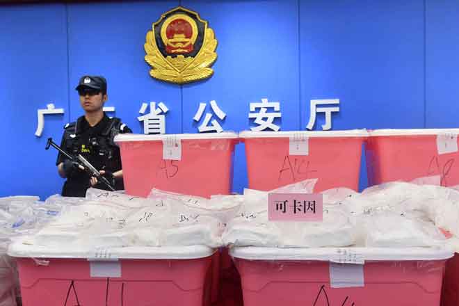  Polis berkawal di sebelah kokain yang dirampas di Guangdong, China kelmarin. — Gambar AFP