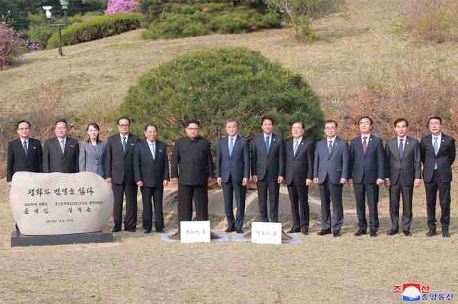  Kim (enam kanan) dan Moon (tujuh kanan) turut serta dalam majlis penanaman pokok bersebelahan dengan Garisan Pembatasan Ketenteraan yang membentuk dua sempadan Korea di kampung kedamaian sementara Panmunjom. — Gambar AFP