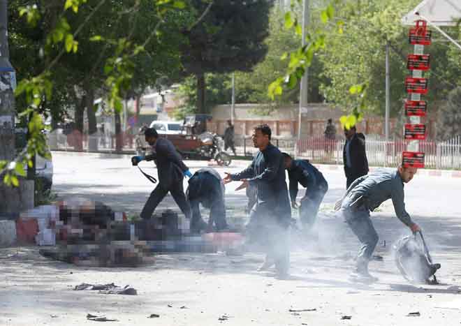  Anggota polis bergegas membantu wartawan dan mangsa letupan bom kedua di Kabul, Afghanistan semalam. — Gambar Reuters